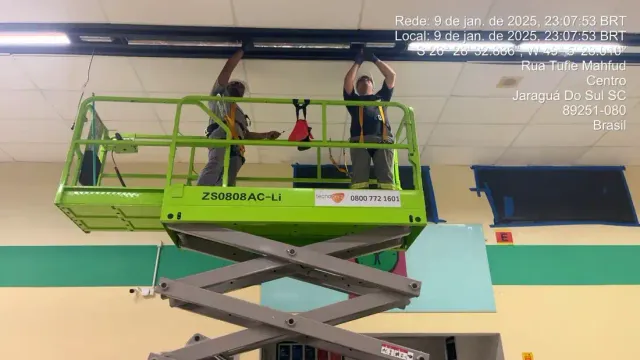 Trabalhador em plataforma elevatória durante serviço industrial